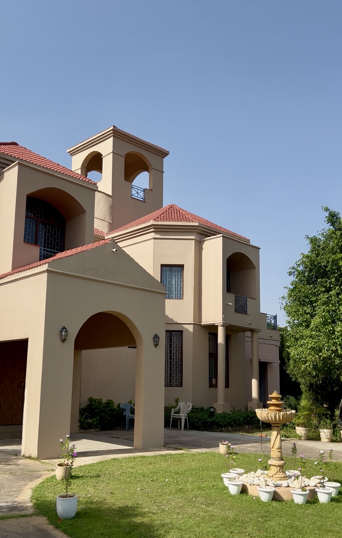 Villa facade with arches, the tower and the garden fountain