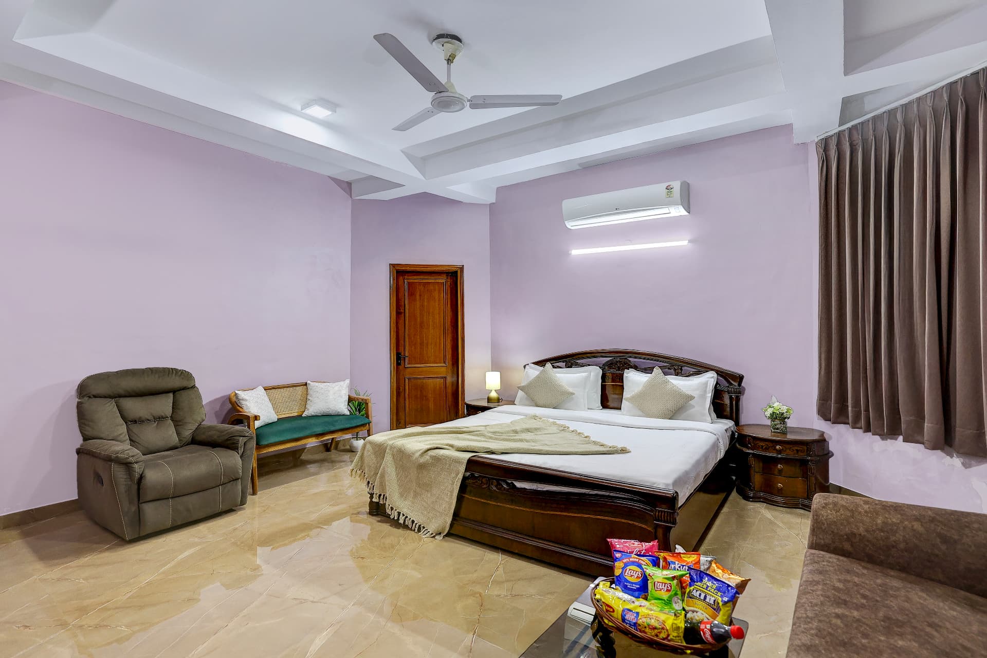 Lilac bedroom with king bed, recliner and cane daybed