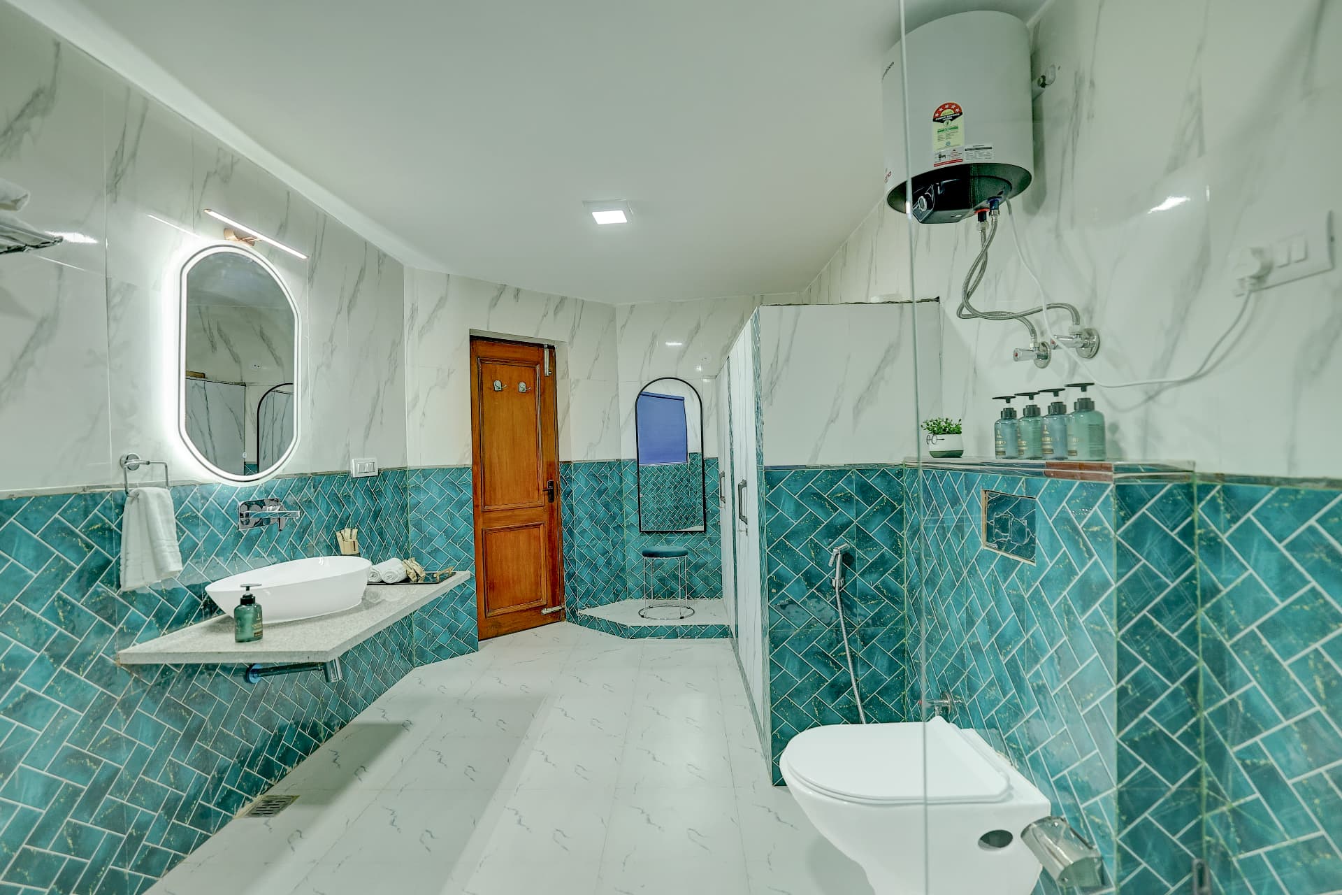Ensuite bathroom with teal herringbone tiles and glass shower